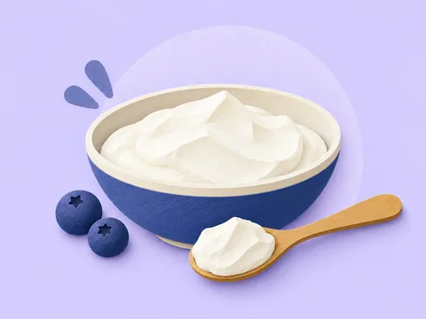 A blue bowl of thick skyr, a spoonful and two blueberries